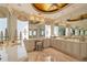 A luxurious bathroom vanity with a marble countertop, decorative mirrors, and custom lighting fixtures exudes elegance and style at 845 Longboat Club Rd, Longboat Key, FL 34228