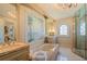 Luxurious bathroom with a soaking tub, marble floors, and a separate shower at 845 Longboat Club Rd, Longboat Key, FL 34228
