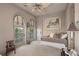 Cozy bedroom with a ceiling fan, two arch-topped doors to the outside, and a comfortable daybed and carpeted floor at 845 Longboat Club Rd, Longboat Key, FL 34228