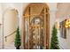 A golden elevator, encased in decorative metal and glass, adds a touch of opulence to the grand foyer at 845 Longboat Club Rd, Longboat Key, FL 34228