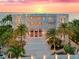 Stunning beachfront estate with multi-level balconies, lush palms, grand entrance, and breathtaking sunset views at 845 Longboat Club Rd, Longboat Key, FL 34228