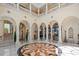 Elegant two-story foyer with marble floors, arched doorways, columns and decorative lighting at 845 Longboat Club Rd, Longboat Key, FL 34228