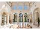 Grand two-story foyer with marble floors, elegant columns, arched doorways and decorative lighting at 845 Longboat Club Rd, Longboat Key, FL 34228