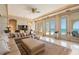 Large living room featuring a wet bar, multiple windows and balcony access at 845 Longboat Club Rd, Longboat Key, FL 34228