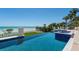 Resort-style pool with an ocean view, glass railings, a spa, outdoor seating, and direct beach access at 845 Longboat Club Rd, Longboat Key, FL 34228