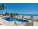 Inviting pool with ocean views, outdoor seating, and beautiful landscaping at 845 Longboat Club Rd, Longboat Key, FL 34228