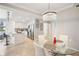 Bright dining area with stylish chandelier, glass table, and adjacent modern kitchen with white cabinets at 850 Tidewater Shores Loop # 108, Bradenton, FL 34208