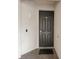 Close up of a front door with a dark mat outside and a light on the wall at 850 Tidewater Shores Loop # 108, Bradenton, FL 34208