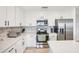 Spacious kitchen with stainless steel appliances, white cabinetry, modern backsplash and bright white quartz countertops at 850 Tidewater Shores Loop # 108, Bradenton, FL 34208