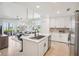 Bright kitchen with white cabinets, stainless steel appliances, island with bar seating, and an open view to the living area at 850 Tidewater Shores Loop # 108, Bradenton, FL 34208