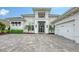 Beautiful white home featuring a modern black front door and paved driveway at 8537 Pavia Way, Bradenton, FL 34202