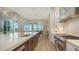 Modern kitchen with stainless steel appliances, a quartz countertop island, and a view to the dining area at 8537 Pavia Way, Bradenton, FL 34202