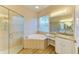 Bathroom featuring a glass shower, tub, vanity with granite counter, and wood-look tile floor at 8772 Stone Harbour Loop, Bradenton, FL 34212