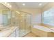 Elegant bathroom featuring a glass-enclosed shower, garden tub, and double vanity at 8772 Stone Harbour Loop, Bradenton, FL 34212