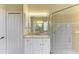 Bathroom with glass shower, granite countertop, and white cabinets at 8772 Stone Harbour Loop, Bradenton, FL 34212