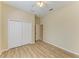 Light bedroom featuring wood-look floors, ceiling fan, and closet at 8772 Stone Harbour Loop, Bradenton, FL 34212