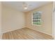 Bedroom with wood-look floors, a ceiling fan, and a view to the yard at 8772 Stone Harbour Loop, Bradenton, FL 34212