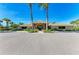 Exterior of the community clubhouse with decorative landscaping and palm trees under a blue sky at 8772 Stone Harbour Loop, Bradenton, FL 34212
