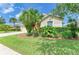 Beautifully landscaped front yard with green grass, mulch beds, and a mature palm tree at 8772 Stone Harbour Loop, Bradenton, FL 34212