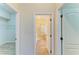 Hallway featuring a view into an ensuite bathroom with glass shower and tile flooring at 8772 Stone Harbour Loop, Bradenton, FL 34212