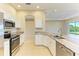 Modern kitchen with stainless steel appliances, granite counters, and white cabinetry overlooking the living space at 8772 Stone Harbour Loop, Bradenton, FL 34212