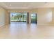 Bright living room featuring neutral tile floors and large sliding glass doors with a serene lake view at 8772 Stone Harbour Loop, Bradenton, FL 34212