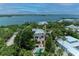 Stunning aerial view of coastal home with pool and lush landscaping, nestled near the bay at 8963 Fishermens Bay Dr, Sarasota, FL 34231