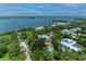 Aerial view of several homes nestled amongst lush trees near bay waters at 8963 Fishermens Bay Dr, Sarasota, FL 34231