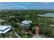 Aerial view of the home surrounded by lush tropical landscaping near the water at 8963 Fishermens Bay Dr, Sarasota, FL 34231