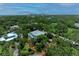 A sprawling two-story home nestled among mature trees with a glimpse of a private pool from above at 8963 Fishermens Bay Dr, Sarasota, FL 34231