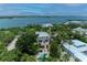 Aerial view of home surrounded by lush foliage, waterfront, and has a pool and brick paver pathways at 8963 Fishermens Bay Dr, Sarasota, FL 34231