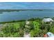 Panoramic aerial view showcasing a waterfront property with lush greenery and direct access to the bay at 8963 Fishermens Bay Dr, Sarasota, FL 34231