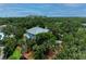 Beautiful aerial shot of a two-story home surrounded by lush trees and colorful landscaping at 8963 Fishermens Bay Dr, Sarasota, FL 34231