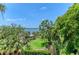 Picturesque waterfront view overlooking the manicured lawn and lush tropical foliage at 8963 Fishermens Bay Dr, Sarasota, FL 34231