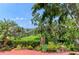 Picturesque waterfront view overlooking the manicured lawn and lush tropical foliage at 8963 Fishermens Bay Dr, Sarasota, FL 34231