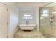 Bright bathroom showcasing a classic clawfoot tub and a modern, glass-enclosed shower with tiled walls at 8963 Fishermens Bay Dr, Sarasota, FL 34231