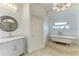 A bright bathroom has a claw foot tub and marble topped vanity at 8963 Fishermens Bay Dr, Sarasota, FL 34231