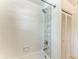 Close up on a bathtub and shower with updated white tiles, decorative accent and new shower head at 8963 Fishermens Bay Dr, Sarasota, FL 34231