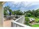 Outdoor deck with dining area overlooking the manicured yard with inground pool and lush greenery at 8963 Fishermens Bay Dr, Sarasota, FL 34231