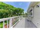 Spacious deck with white railing, showcasing outdoor seating and scenic treetop views under a sunny sky at 8963 Fishermens Bay Dr, Sarasota, FL 34231