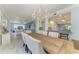 Open-concept dining area with chandelier flowing into the living room and modern kitchen at 8963 Fishermens Bay Dr, Sarasota, FL 34231