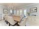 Elegant dining room with fireplace, chandelier, and views through French doors at 8963 Fishermens Bay Dr, Sarasota, FL 34231