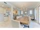 Light-filled dining room featuring a rustic wood table, chandelier, and seamless flow to the kitchen at 8963 Fishermens Bay Dr, Sarasota, FL 34231