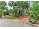 Home with tropical landscaping, brick driveway and walkway at 8963 Fishermens Bay Dr, Sarasota, FL 34231