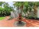 Home with tropical landscaping and decorative water fountain at front entrance at 8963 Fishermens Bay Dr, Sarasota, FL 34231