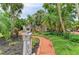 Charming home surrounded by lush tropical landscaping and a brick walkway at 8963 Fishermens Bay Dr, Sarasota, FL 34231