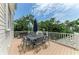 Outdoor patio featuring a dining table set and grill, surrounded by lush greenery and a blue sky backdrop at 8963 Fishermens Bay Dr, Sarasota, FL 34231