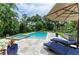 Beautiful pool and spa surrounded by a stone patio, lounge chairs, and lush tropical landscaping at 8963 Fishermens Bay Dr, Sarasota, FL 34231