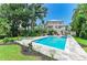 Spacious backyard featuring a sparkling pool, lush landscaping, and a charming two-story home at 8963 Fishermens Bay Dr, Sarasota, FL 34231