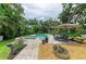Inviting pool and spa area with comfortable lounge chairs, an umbrella, and lush tropical landscaping at 8963 Fishermens Bay Dr, Sarasota, FL 34231